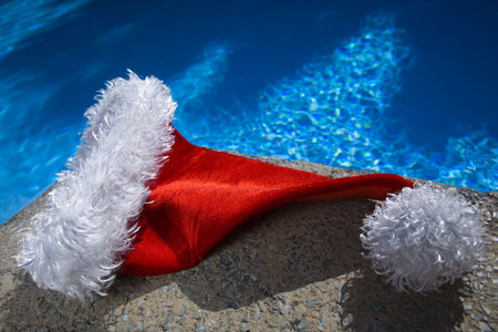 Nice santa hat by a blue swimming poolの写真素材