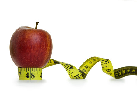 Red apple and tape measure with white background