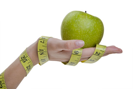 Hands holding Green apple while wrapped in measuring tape.の写真素材