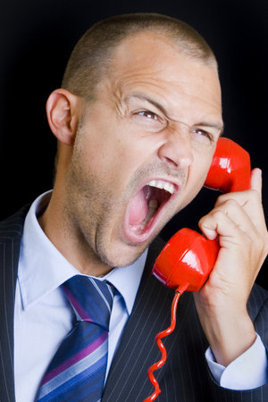 Man shouting into a red telephoneの写真素材