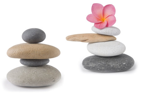 Two zen , stone stacks, one with a pink frangipani or plumeria flowerの写真素材