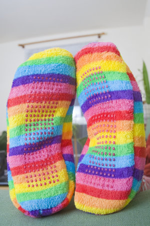 Colorful pair of slippers on the end of a sofa.の写真素材