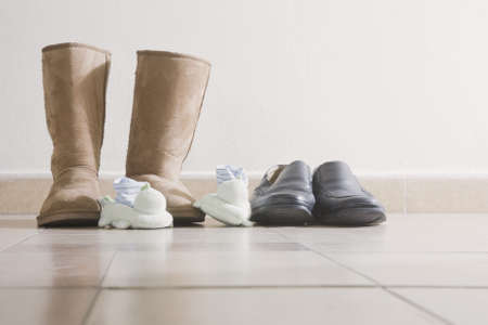 Three pairs of shoes by the front door of a home.の写真素材