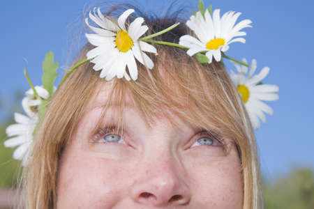 Smiling woman with a daisy chain around her head.の写真素材