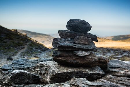 Short green grass contrasts the grey rocks and deep. blue sky of the early morning atop the Mulhacen mountain - Mainland Spain's highest pointの写真素材