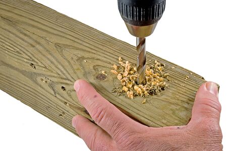 Hand holding board that is being drilled intoの写真素材