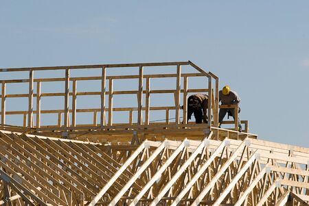 Two man working on top of a building under constructionの写真素材