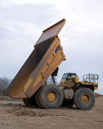 Large yellowdumptruck with bed elevatedの写真素材