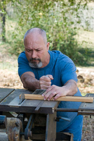 Man using table saw to cut boardの写真素材