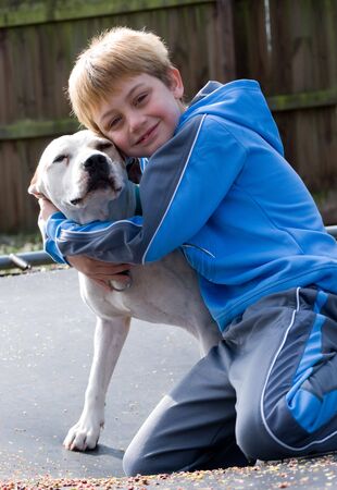 Boy hugging his pit bull dogの写真素材