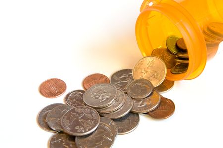 Coins pouring from a pill bottleの写真素材