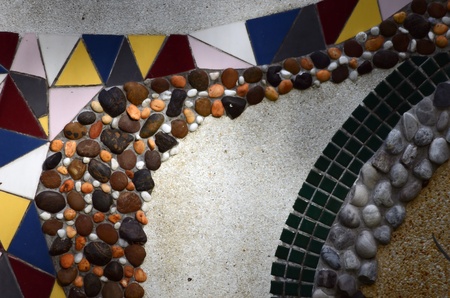 Art of pebble and colorful tile on concrete surface.