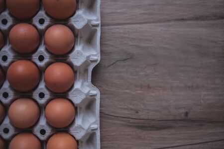Rustic background of an egg carton on a wooden board