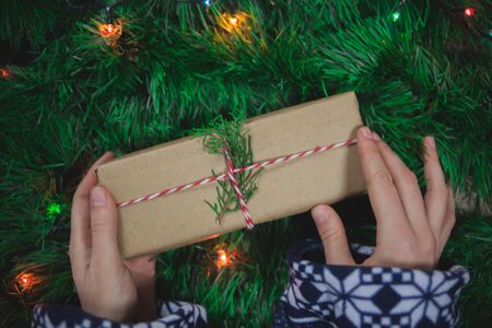 Young woman catching a gift with Christmas tree background and lights