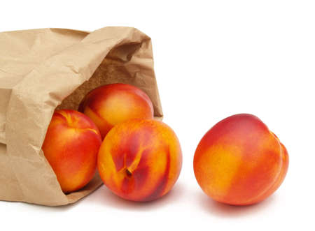 nectarines tumbling out of a brown paper bagの写真素材