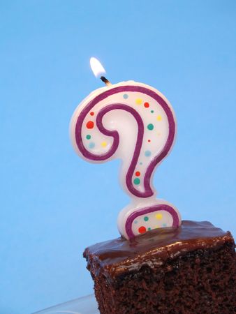birthday cake with a question mark candle lit on topの写真素材