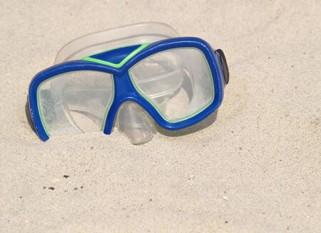 blue swim mask on the sand of a beachの写真素材