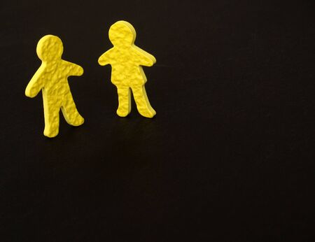 textured yellow male and female figures standing beside each otherの写真素材