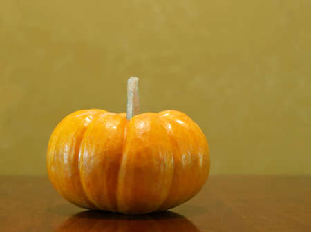 a single mini pumpkin sitting on a tableの写真素材
