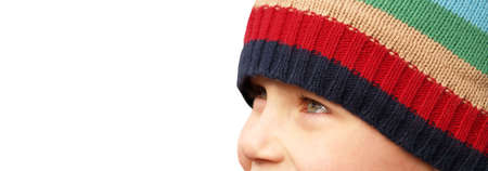 young boy's smiling eyes under a striped winter hat 