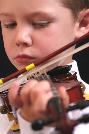Cute young boy playing the violin.の写真素材