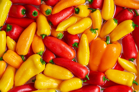Vegetarian textures. Group of fresh delicious bell peppers: red, yellow and orange. Vegetable...