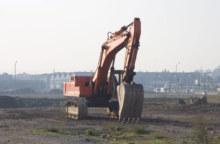 A backhoe sits idle at a new construction site.
