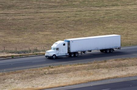 A tractor-trailer truck in cruising along the highway.の写真素材