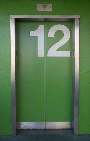 A green elevator with the number twelve painted on it - Going up or down?