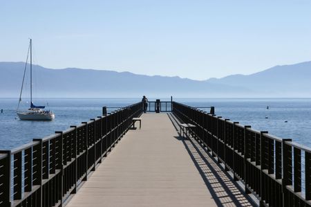 A pier extends into a beautiful mountain lake.の写真素材
