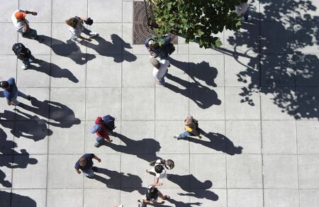 A bird's eye view of a crowd of people strolling down a sidewalk.の写真素材