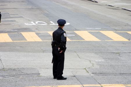 A police officer stands into the street.の写真素材