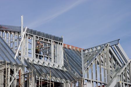 A worker cuts metal supports at a construction site.の写真素材