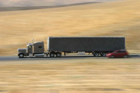 A tractor-trailer hauls some stuff down the highway.