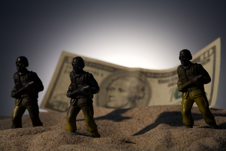 Silhouette of military soldiers on money backgroundの写真素材