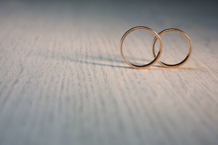 Two wedding rings on wood backgroundの写真素材