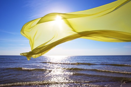 yellow tissue flying over the seaの写真素材