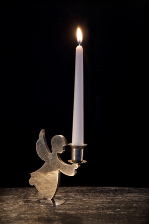 burning candle in vintage candlestick on blackの写真素材