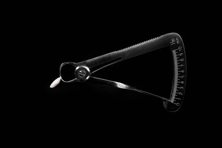 ceramic tooth crown and dental tool on blackの写真素材