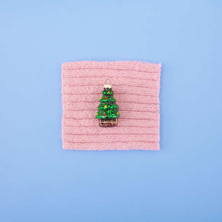 Christmas tree toy on wool and pastel background. Top view.