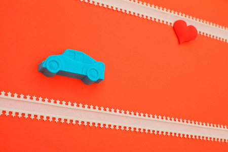 kinetic sand car and red heart on pink background