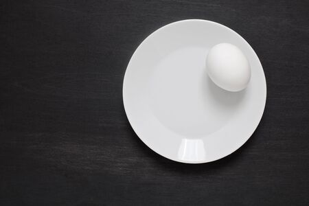 White eggs on a plate on woodenの写真素材