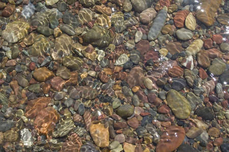 River rocks on a stream bed with water flowing over them.
