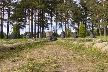 The forest road is lined with stones with a stone at the end.の写真素材
