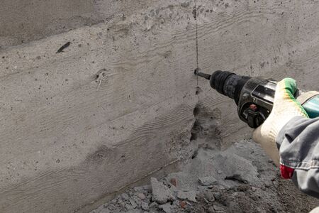 People are using electric drill,He drilled concrete to put steel anchor.の写真素材