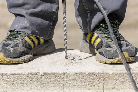 People are using electric drill,He drilled concrete to put steel anchor.の写真素材