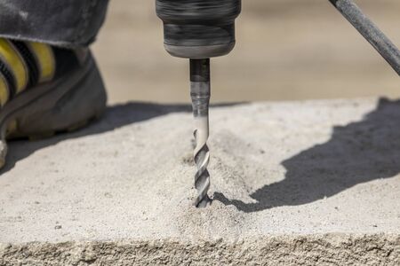 People are using electric drill,He drilled concrete to put steel anchor.の写真素材