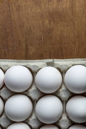 Chicken eggs are raw in the tray. The shell is white in eggs. In one section is an egg shell. On one...