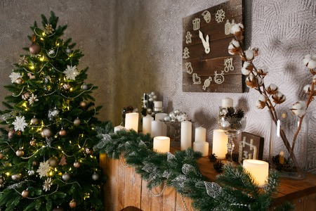 New Year decorations, a Christmas tree, garlands and balls home cosiness with a fireplace and candlesの写真素材