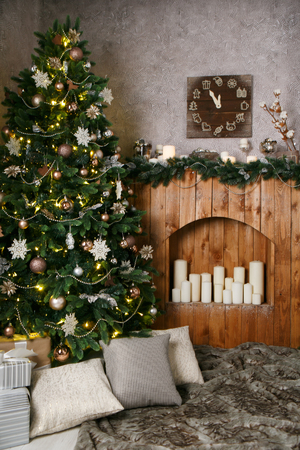 New Year decorations, a Christmas tree, garlands and balls home cosiness with a fireplace and candlesの写真素材
